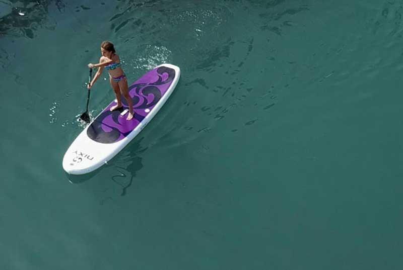 A child riding on a NIXY inflatable paddleboard