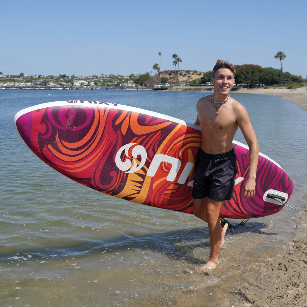 NIXY Huntington G5 Compact Paddle Board, man carrying the lightweight board to the shoreline