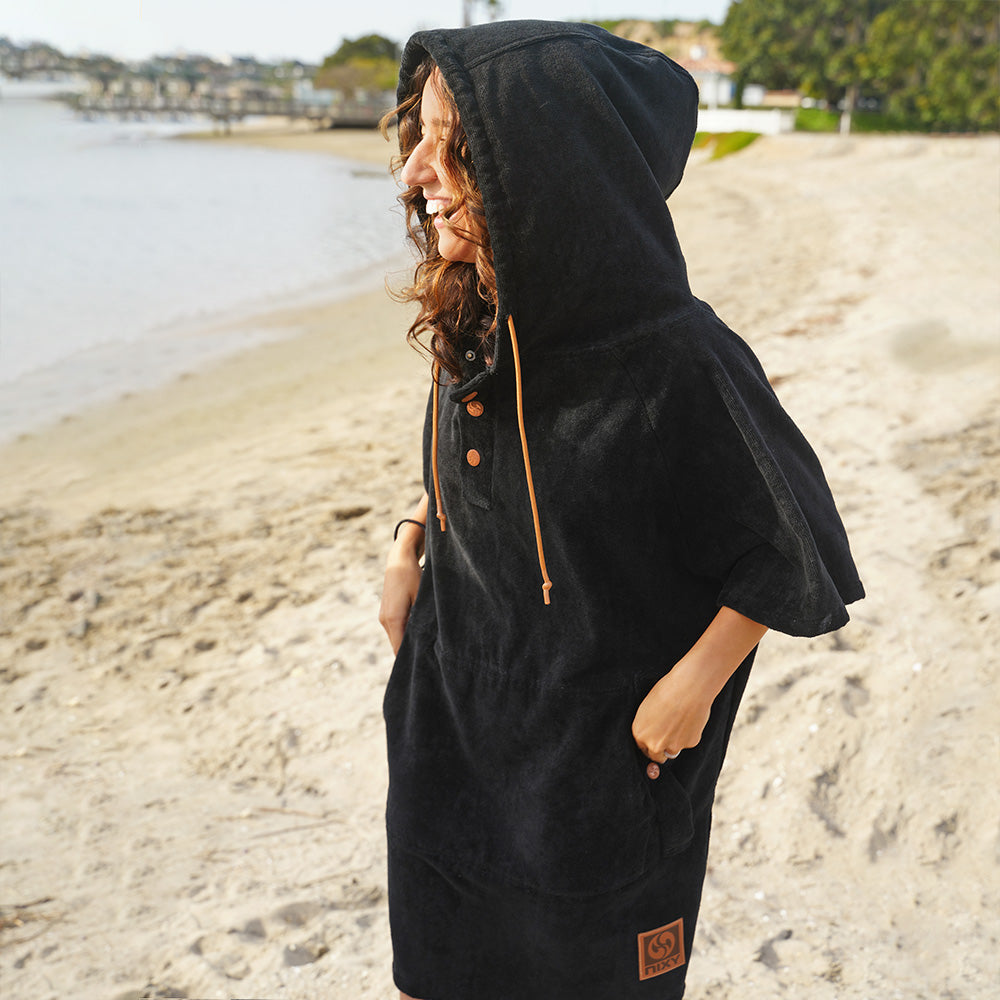 Model wearing a NIXY Changing Poncho with the hood up at the beach