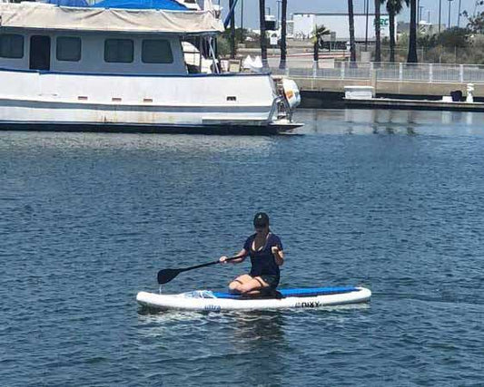 Paddleboarder gliding on the water's surface in front of a boat