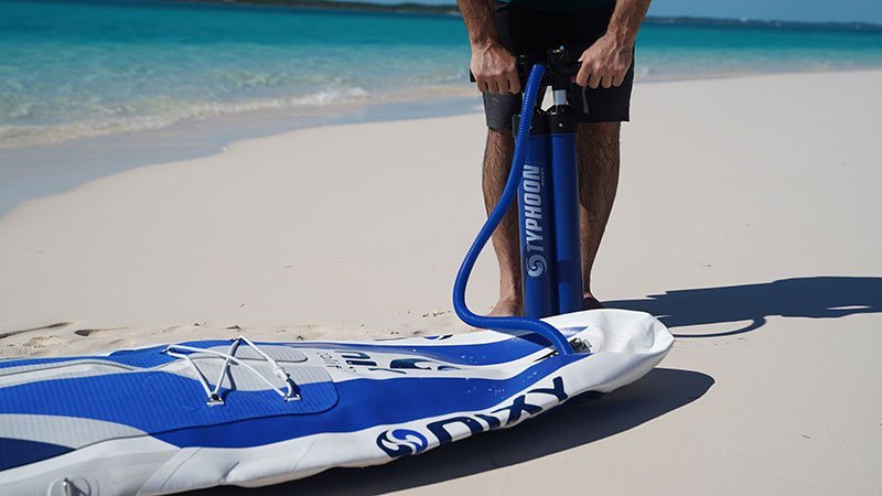 NIXY inflatable paddleboard being pumped up on the beach
