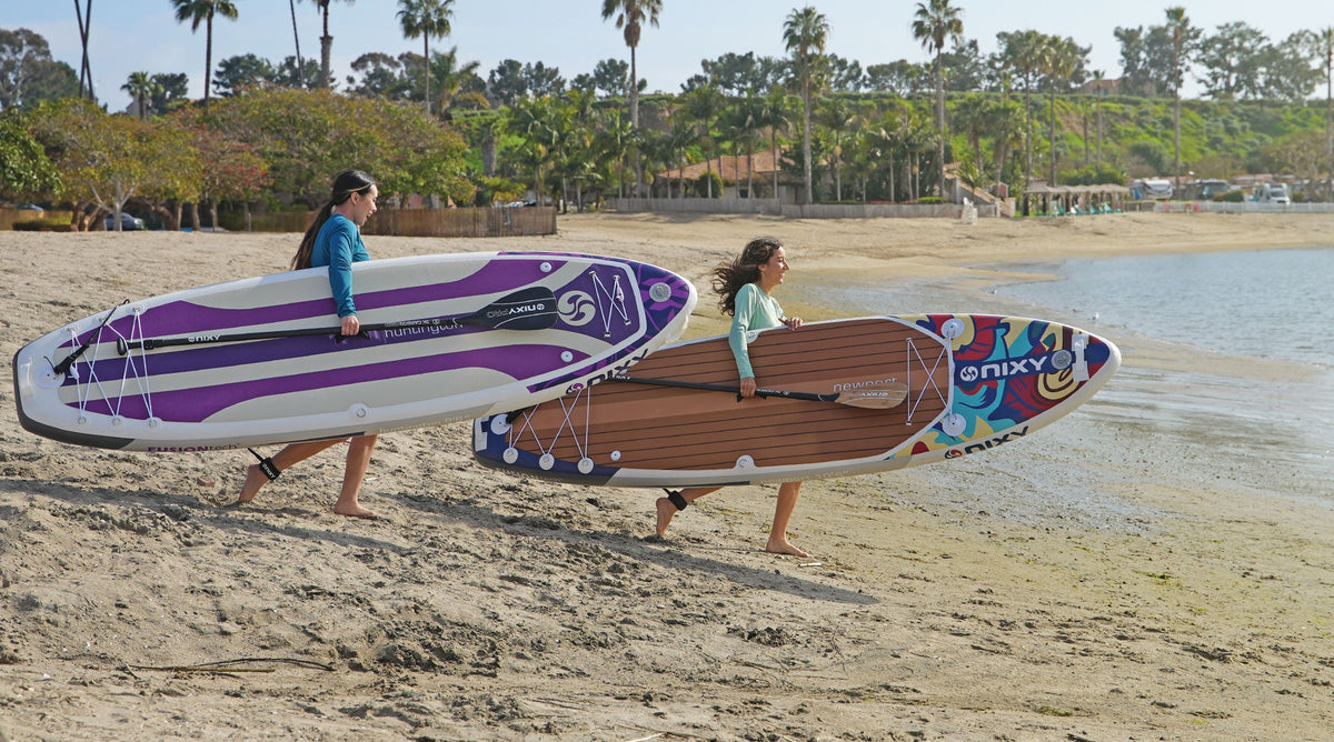 NIXY G5 Premium Inflatable Stand-Up Paddleboards being carried to the water