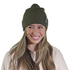 Smiling woman wearing earth green NIXY Sports classic cuffed knit beanie – ribbed unisex winter hat for men and women, perfect for outdoor adventures and cold-weather paddleboarding