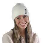 Smiling woman wearing pearl white NIXY Sports classic cuffed knit beanie – unisex winter hat for men and women, ideal for snow days, paddleboarding, and cold-weather outdoor sports