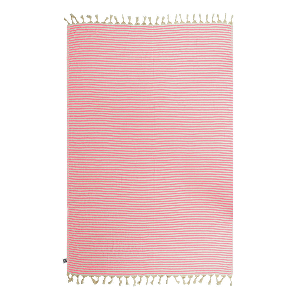 Pink and white striped NIXY Mediterranean Turkish cotton beach towel with tassels on a white background.
