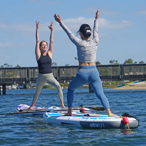 Women practicing yoga poses on a NIXY G5 Venice inflatable paddleboard