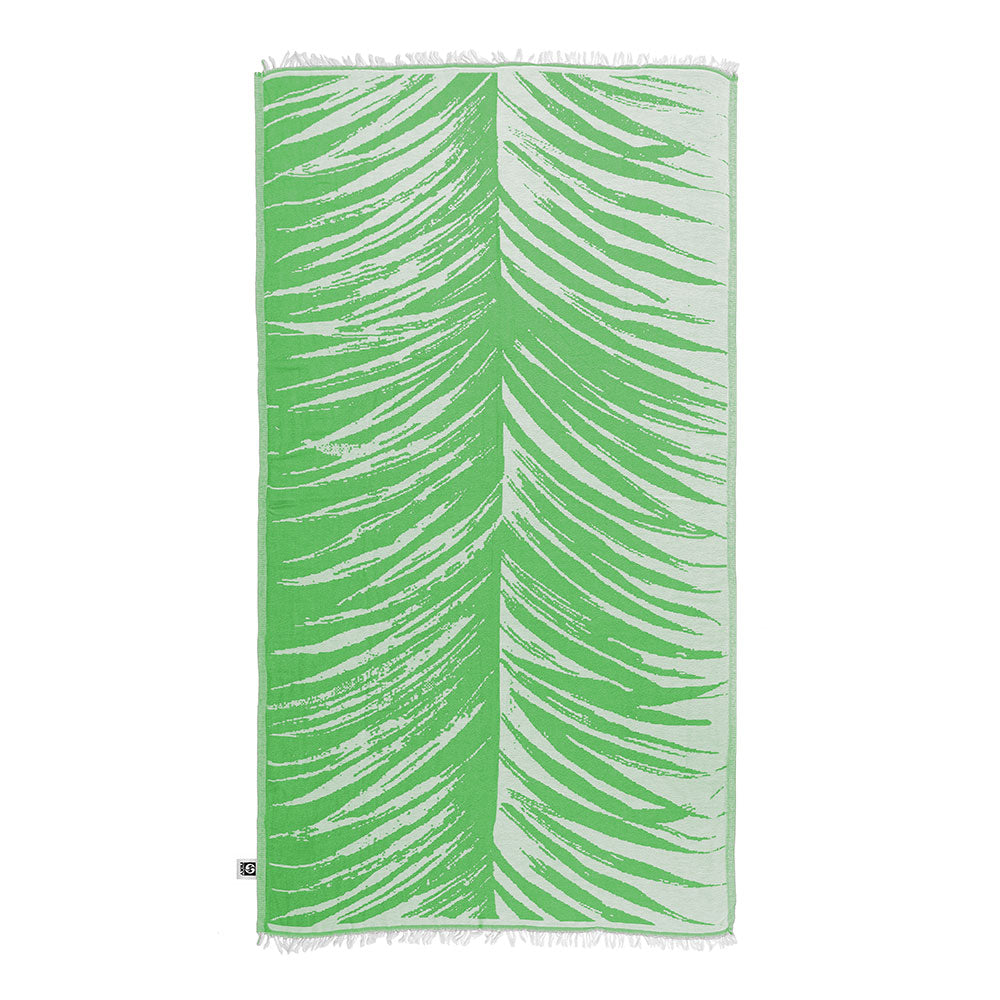 NIXY Palm Turkish Beach Towel in Lime rolled and styled on a white background