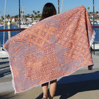 Person holding a patterned Turkish Cotton beach towel by a marina