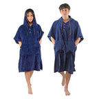 Man and women wearing blue NIXY towel changing ponchos with a white background.