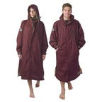 Woman and man wearing NIXY maroon waterproof changing parka - unisex hooded weatherproof robe for surfing, swimming, and cold-water sports