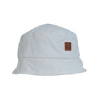 NIXY Vibe Bucket Hat in White front product view with leather NIXY logo patch and downward sloping wide brim, 100% high grade cotton unisex trendy bucket hat, lightweight breathable sun hat for men and women, ideal for beach and outdoor adventures