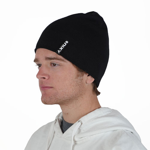 Man wearing black NIXY Sports classic skull beanie – uncuffed slouchy men's winter hat styled with white hoodie for cold-weather outdoor sports