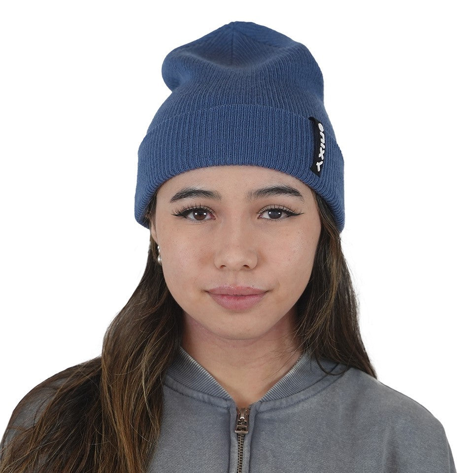 Woman wearing navy blue NIXY Sports classic cuffed knit beanie – women's winter hat paired with gray zip-up sweatshirt for casual cold-weather style