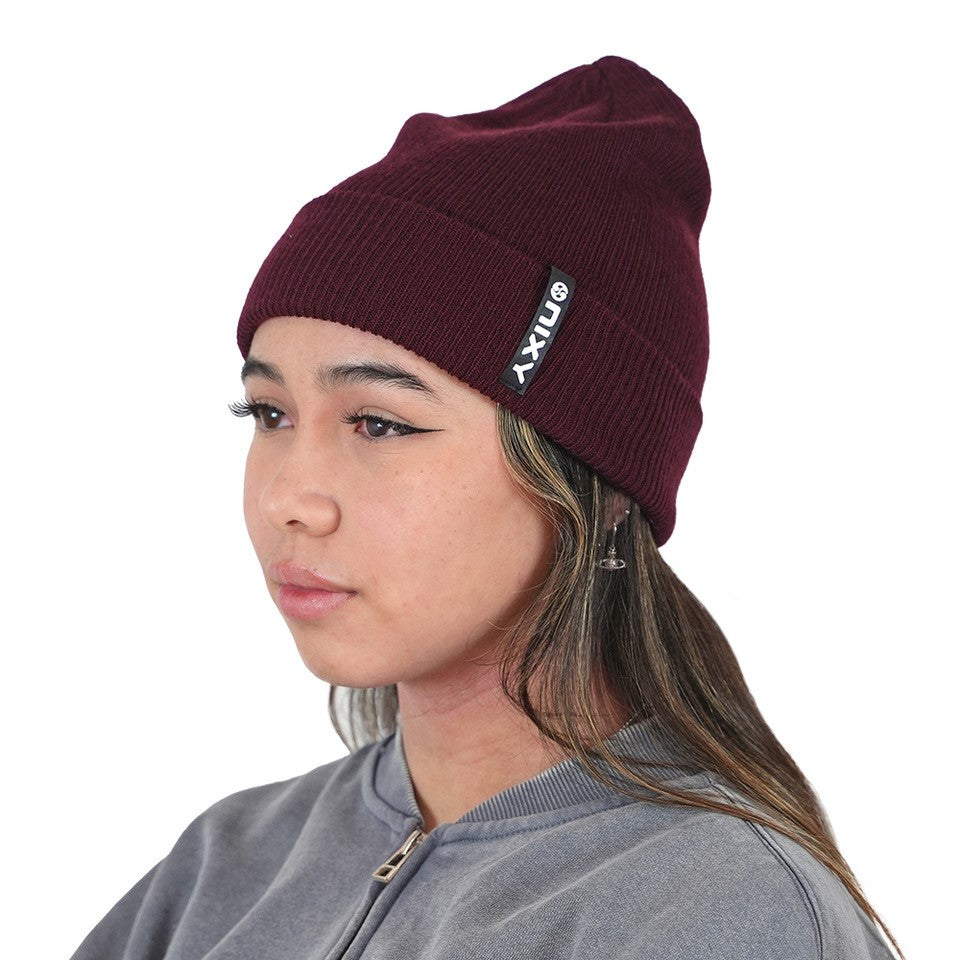 Woman in side profile wearing merlot maroon NIXY Sports classic cuffed knit beanie – women's winter hat styled with gray sweatshirt for fall and cold-weather outfits