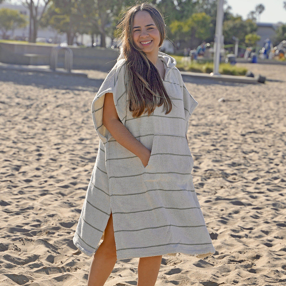 Woman standing on a beach wearing a NIXY Everest Turkish cotton Changing poncho for adults