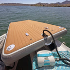 nixy 5 by 10 foot floating deck being inflated with electric pump at lakeside with mountain backdrop
