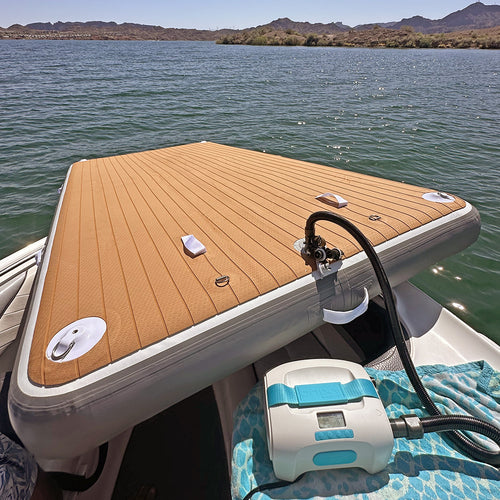 nixy 5 by 10 foot floating deck being inflated with electric pump at lakeside with mountain backdrop