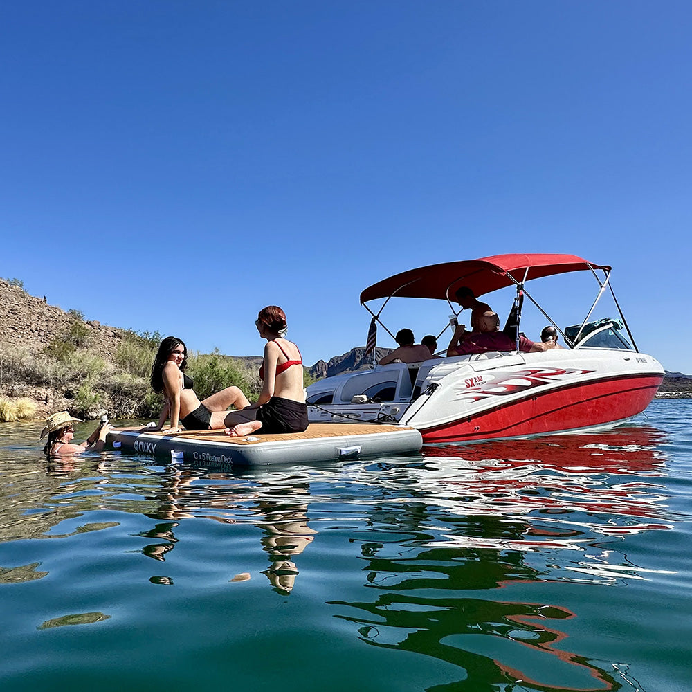 friends hanging out on nixy 5 by 10 floating deck next to a speedboat on a sunny day at the lake