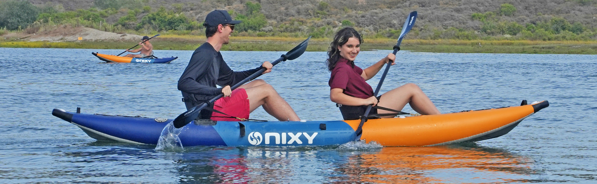 NIXY Tahoe 150 Inflatable Kayak for two people on the water while a man and a woman paddle
