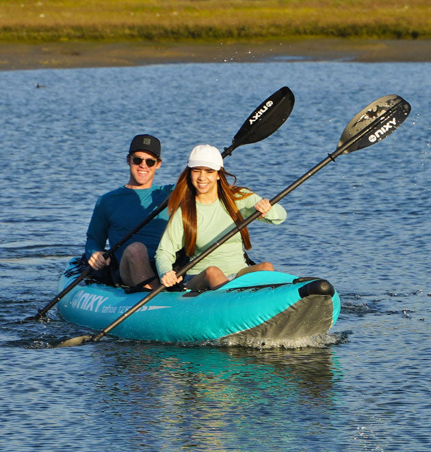 Man and women paddling together on the NIXY tandem inflatable kayak