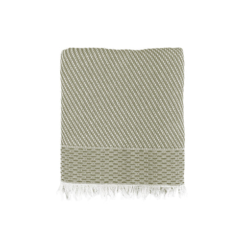 Green and beige woven Turkish cotton beach towel with fringes on a white background