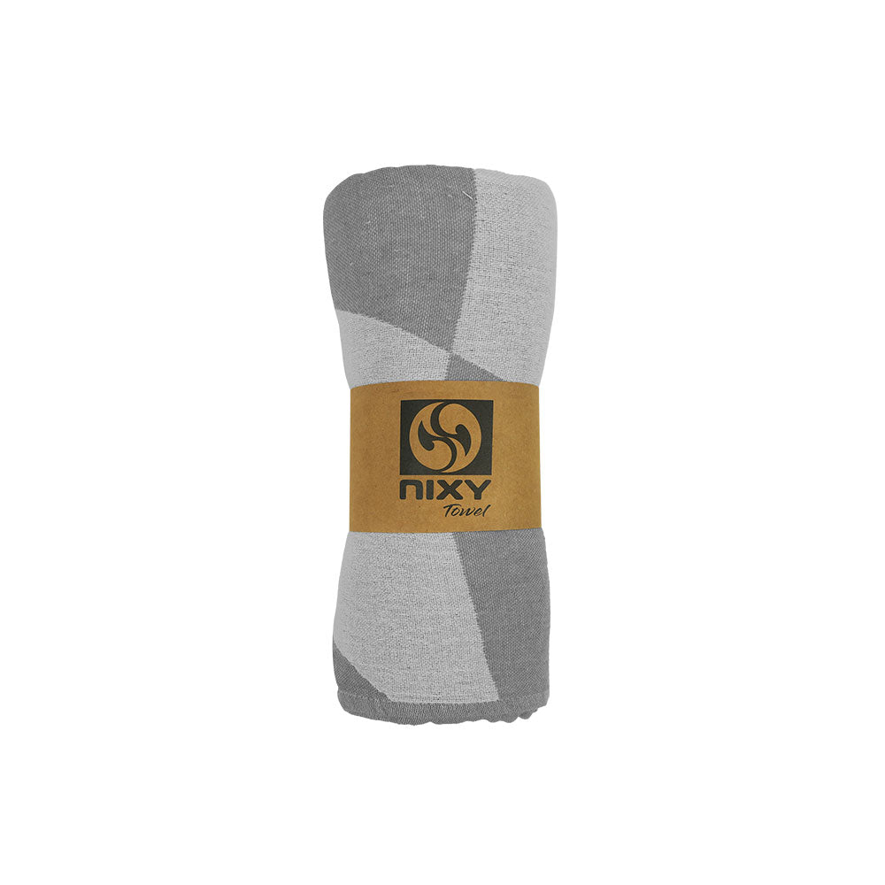NIXY Squares Recycled Turkish Beach Towel in Gray rolled and styled on a white background
