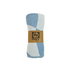 NIXY Squares Recycled Turkish Beach Towel in Light Blue rolled and styled on a white background