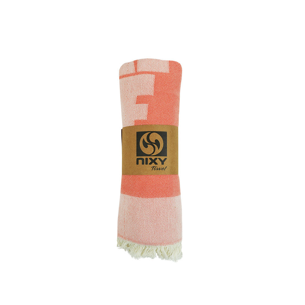 NIXY Surf Turkish Beach Towel rolled and styled on a white background, built for changing room and post-surf use