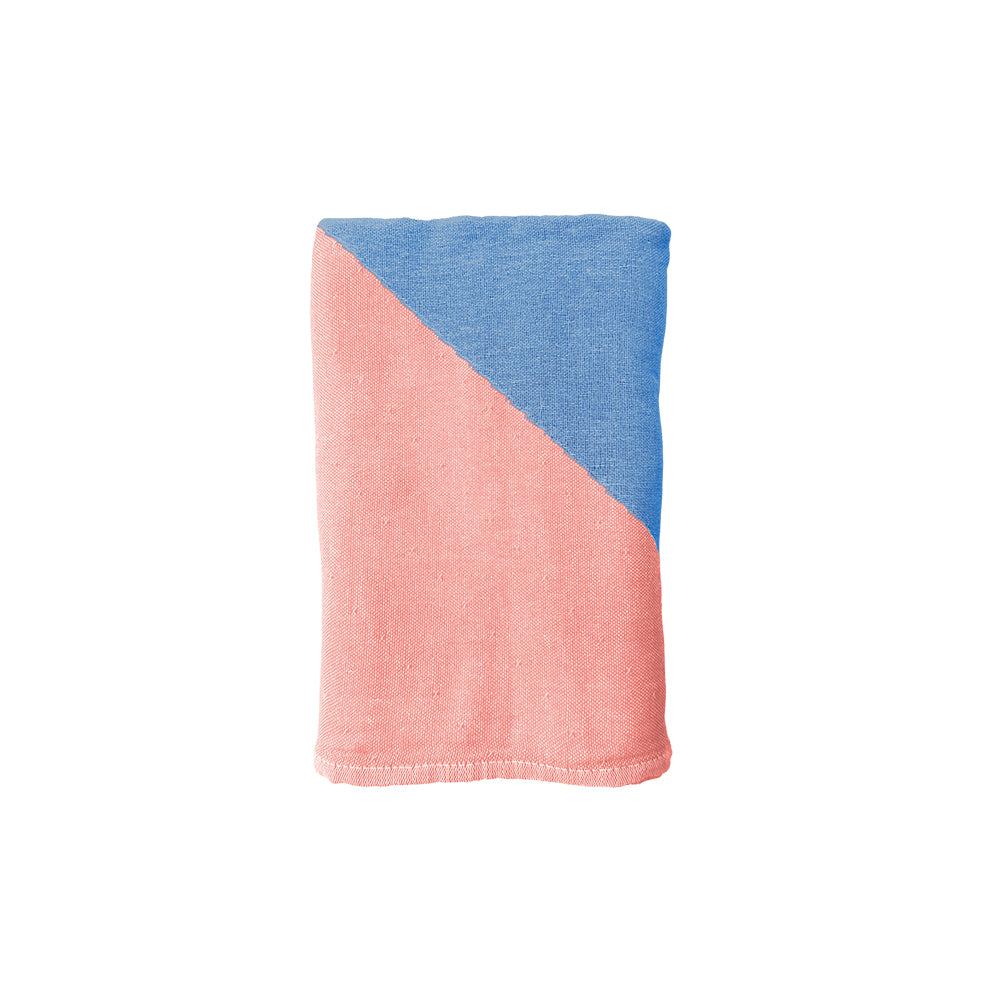 NIXY Parallax Recycled Turkish Cotton Beach Towel (Coral Blue). A folded beach towel with bold diagonal stripes in light blue and pink, shown flat against a white background.