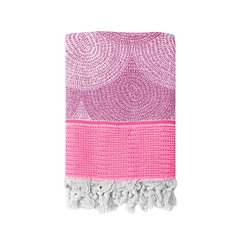 Pink textured Turkish towel with white tassels on a white background